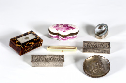 824.  Lote formado por seis cajas y un platito de plata, una de porcelana esmaltada con paisaje, dos cajas de plata con decoración repujada de amorcillos del S. XX, otra de marfil de forma ovalada del S. XIX. y una caja inglesa de carey y nácar con iniciales de.