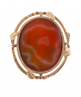 12.  Broche guardapelo S. XIX oval con ágata cornalina en anverso y reverso con tapa de cristal que protege cavidad interior