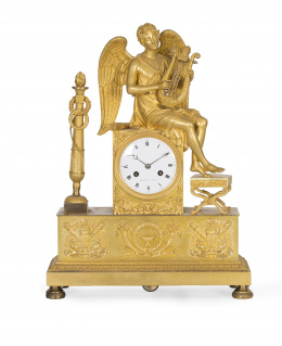 663.  Reloj de sobremesa Imperio en bronce dorado. Sobre basamento rectangular, sobre la que se sitúa figura del Amor con lira en la mano, sentado sobre esfera de reloj en porcelana. Firmada “Rabelle a París”.Francia, primer tercio S. XIX