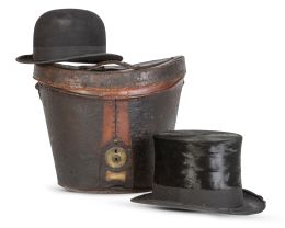 670.  Sombrerera de piel con cerradura metálica y asa en la tapa, con dos sombreros en el interior.Un sombrero de Lincoln Bennet London y otro de Clayton & Sons London, h. 1920-30.