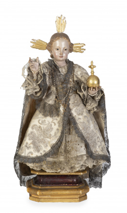 1056.  Niño Jesús como Salvator MundiImagen vestidera de madera tallada y policromada, vestido de seda bordada y aplicaciones.Trabajo español, pp. del S. XIX.