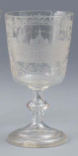 956.  Copa de "recuerdo" fernandina, de vidrio transparente con decoración grabada al ácido, con vista de la colegiata y leyenda que reza: "Recuerdo a Vicenta de sus hermanas 1º Setiembre 1823". La Granja, primer cuarto del S. XIX.