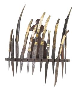 1068.  Conjunto de doce navajas de metal, hueso o asta grabadas con flores. En un soporte de madera.Albacete y otros, S. XIX.