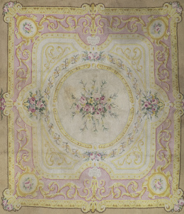 1218.  Alfombra en lana de nudo  español, con campo beige y enefa en rosa con flores. Firmada y Fechada (ilegible).Madrid.