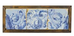 500.  Friso con tres azulejos de cerámica esmaltada en azul de cobalto y blanco, con un querubín, hojas carnosas y cueros recortados.Talavera, h. 1590.