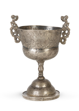 1300.  Copa de plata en su color con asas de doble curvatura, rematados por personajes.Bolivia, finales del S. XVIII - principios del S. XIX.
