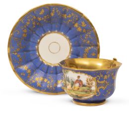 665.  Taza de porcelana esmaltada en azul con escena pastoril en cartela sobre plato con flores, aves, e insectos.París, S. XIX.