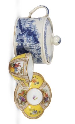 655.  Lote de taza con plato de porcelana esmaltada con escenas galantes y flores, Alemania, S. XX; y azucarero de porcelana esmaltada en azul y blanco, S. XX.