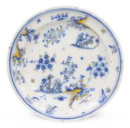 1086.  Plato de cerámica esmaltada en azul de cobalto con tres personajes y pájaro en azul y ocre.Alcora, primera época, serie de chinescos (1735-1760).