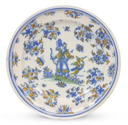 1072.  Plato de cerámica esmaltada en azul de cobalto, ocre, amarillo y verde, decorado con una dama con arco.Alcora, primera época, serie de chinescos (1735-1760).