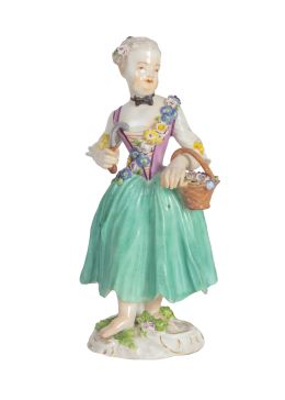 628.  Niña con cesto de flores.Figura escultórica de porcelana esmaltada,sobre base circular con flores.S. XVIII.