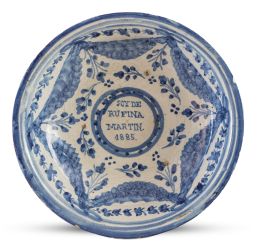 1121.  Plato acuencado de cerámica esmaltada en azul y blanco de la serie de pabellones e inscripción "Soy de Rufina Martin 1885".Talavera, 1885.