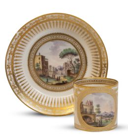 1231.  Taza con su plato de porcelana esmaltada y dorada con decoración de vistas en reservas. Con marca en azul en la baseFábrica Ferdinandea, Nápoles, (1771-1834).